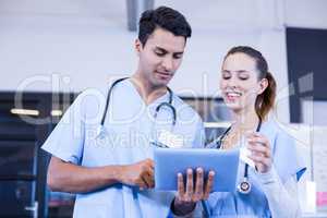 Doctors using digital tablet and smiling