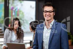 Smiling man and people using laptop