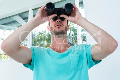 Hipster man looking through binoculars