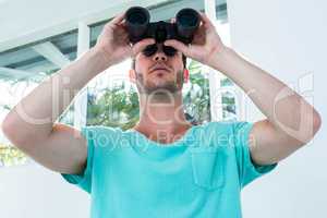 Hipster man looking through binoculars