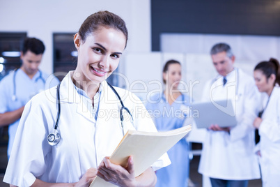 Female doctor holding medical report and smiling at camera