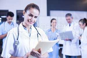 Female doctor holding medical report and smiling at camera