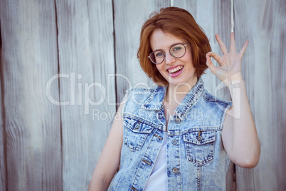 smiling hipster woman giving the "ok" sign