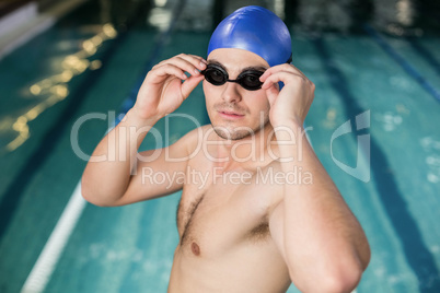 Fit man adjusting his goggles