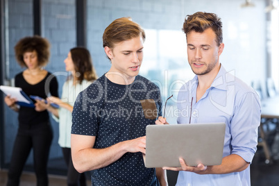 Men looking at laptop and having a discussion