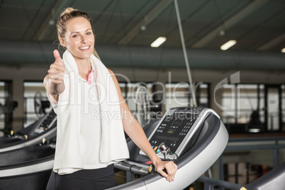 Smiling woman in sportswear showing thumb up