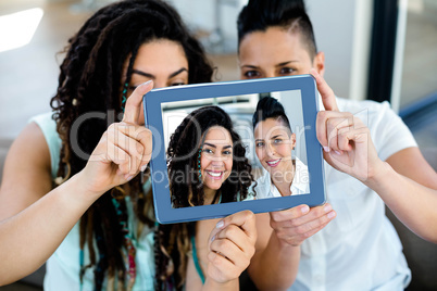 Lesbian couple taking a selfie with digital tablet