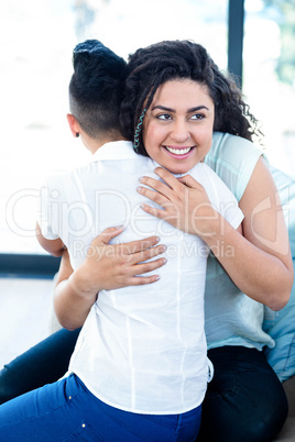 Lesbian couple embracing each other on sofa