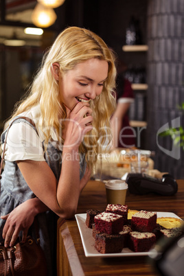 Pretty customer admiring cakes