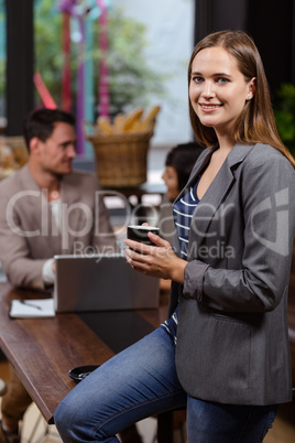 Smiling woman holding a cup of coffee