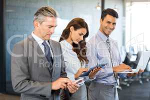 Businesspeople using mobile phone, lap top and digital tablet