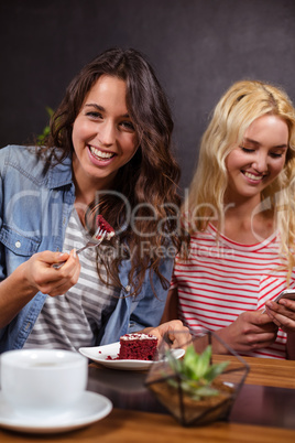 Smiling brunette enjoying a pastry