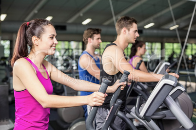 Fit people on elliptical bike