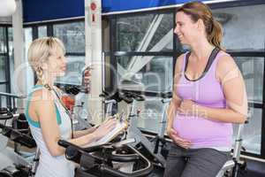 Pregnant woman and trainer talking