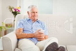 Senior man sitting and watching television at home