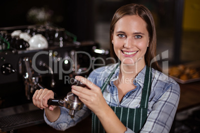 Pretty barista pressing coffee for coffee machine