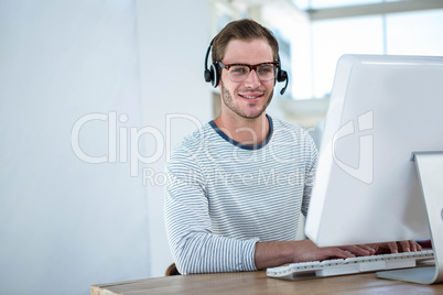 Handsome man working on computer with headset