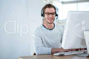 Handsome man working on computer with headset