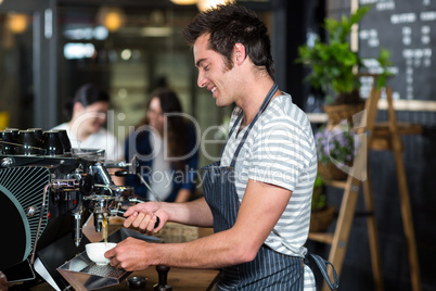 Smiling barista making coffee