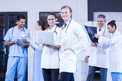 Medical team using laptop, digital tablet and discussing x- ray