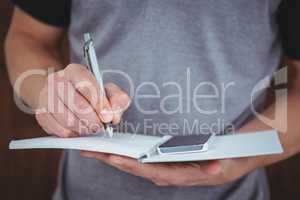 Masculine hands writing on notebook