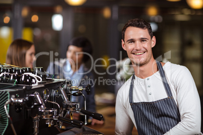 Smiling barista standing with arms crossed