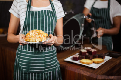 Mid section of barista holding croissants