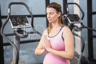 Peaceful pregnant woman with hands together