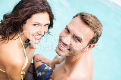 Close-up of young couple sitting by poolside