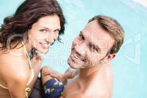Close-up of young couple sitting by poolside