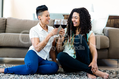 Lesbian couple toasting wine glasses