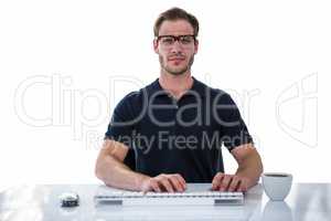 Handsome man using computer while drinking coffee