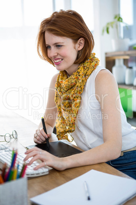 smiling hipster businesswoman writing on a digital drawing table