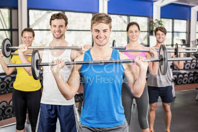 Fitness class lifting barbell