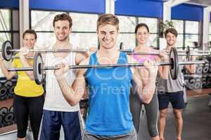 Fitness class lifting barbell