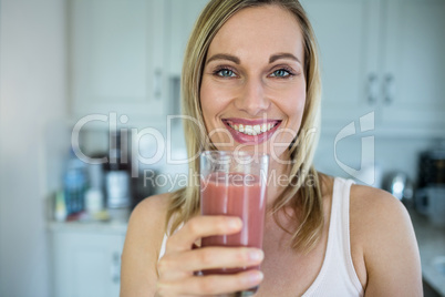 Pretty blonde woman holding her homemade smoothie