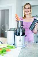 Blonde woman preparing a smoothie in the kitchen