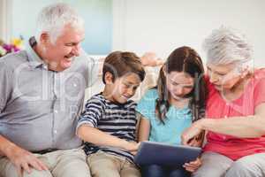 Senior couple using digital tablet with their grand children