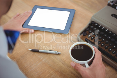 Man using old typewriter and tablet