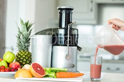 Woman pouring smoothie in a glass
