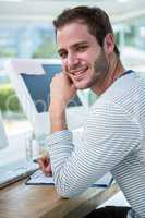 Handsome man working on computer and taking notes