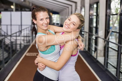 Smiling athletic friends hugging