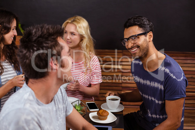 Smiling friends enjoying coffee together