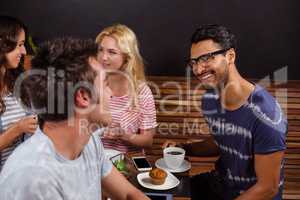 Smiling friends enjoying coffee together