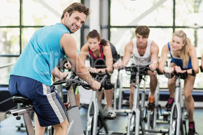 Fit group of people using exercise bike together