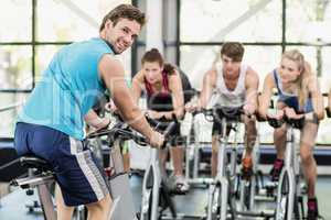 Fit group of people using exercise bike together