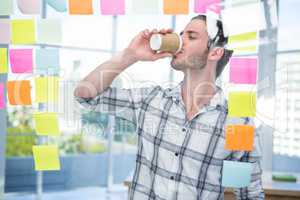 Hipster in front of post-it drinking coffee