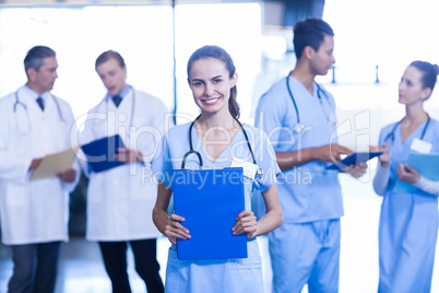 Female doctor holding medical report and smiling at camera