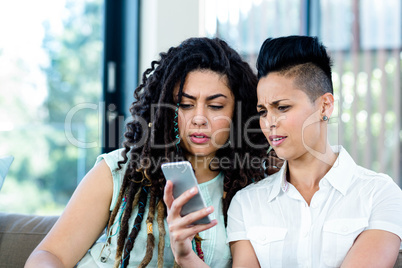 Lesbian couple looking at mobile phone