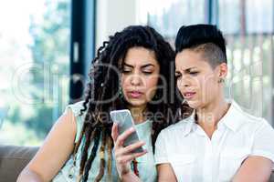Lesbian couple looking at mobile phone